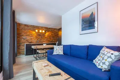 a living room with a blue couch and a table at Appartement Cham-Vue in Chamonix-Mont-Blanc
