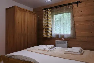 a bedroom with two towels on a bed with a window at Grand chalet Le Trappeur - Chamonix in Chamonix-Mont-Blanc