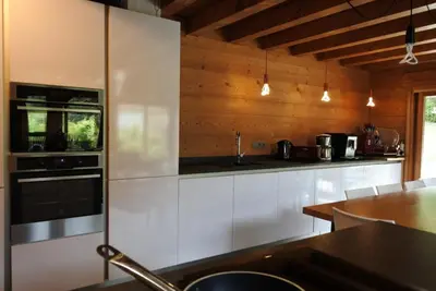 a kitchen with white cabinets and a stove at Grand chalet Le Trappeur - Chamonix in Chamonix-Mont-Blanc