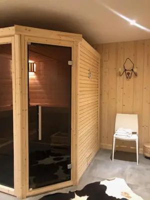 a sauna with a glass door and a chair at Grand chalet Le Trappeur - Chamonix in Chamonix-Mont-Blanc