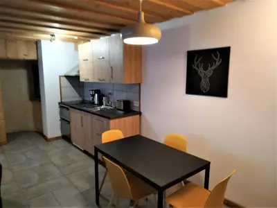 a kitchen with a table and chairs in a room at Appartement dans ferme rénovée au cœur du Grand Massif in Sixt