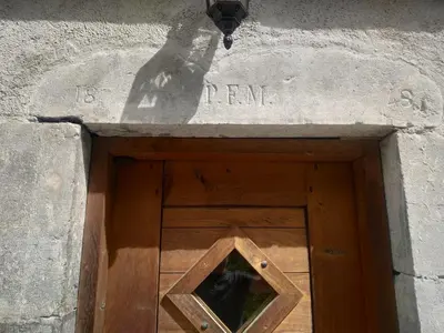 a wooden door with a window in a stone building at Appartement dans ferme rénovée au cœur du Grand Massif in Sixt