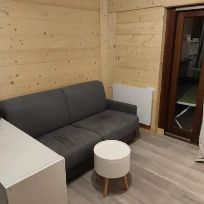 a living room with a couch and a table at Studio tout confort avec vue sur les sommets in Combloux