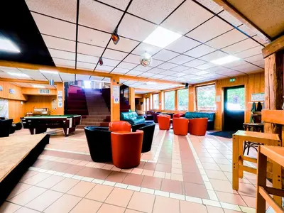 a waiting room with couches and ping pong tables at Auberge de Jeunesse HI Chamonix in Chamonix-Mont-Blanc