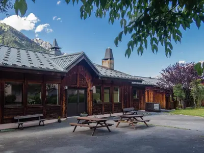 a log cabin with picnic tables in front of it at Auberge de Jeunesse HI Chamonix in Chamonix-Mont-Blanc