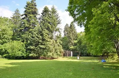 a park with green grass and trees and a waterfall at Résidence du Mont-Blanc n°5Bis in Combloux