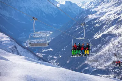 a group of people sitting on a ski lift at Le Beaulieu - Happy Rentals in Chamonix-Mont-Blanc