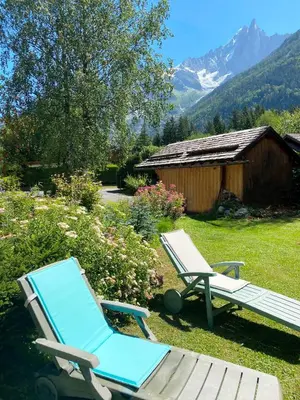 a couple of chairs and a picnic table in a yard at Chalet Champraz Studio - Free Parking in Chamonix-Mont-Blanc