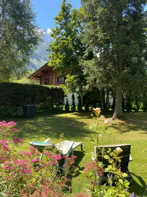a garden with a table and chairs in the grass at Chalet Champraz Studio - Free Parking in Chamonix-Mont-Blanc