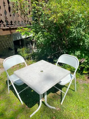 a white table and two chairs on the grass at Chalet Champraz Studio - Free Parking in Chamonix-Mont-Blanc