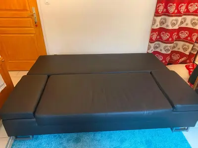 a black bed sitting on top of a blue rug at Chalet Champraz Studio - Free Parking in Chamonix-Mont-Blanc