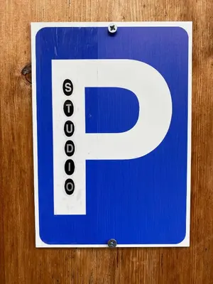 a blue and white parking sign on a wooden wall at Chalet Champraz Studio - Free Parking in Chamonix-Mont-Blanc