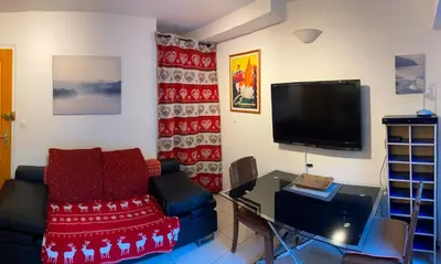 a living room with a couch and a tv at Chalet Champraz Studio - Free Parking in Chamonix-Mont-Blanc