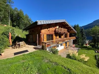 a log cabin with a deck and a house at Chambres d'hôtes - B&B - Chalet Mountain Vibes in Les Houches