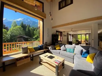 a living room with couches and a large window at Chambres d'hôtes - B&B - Chalet Mountain Vibes in Les Houches