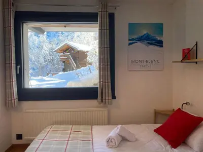 a bedroom with a window with a view of a snow covered mountain at Chambres d'hôtes - B&B - Chalet Mountain Vibes in Les Houches