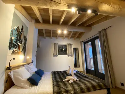 a bedroom with a bed with a stuffed animal on it at Chambres d'hôtes - B&B - Chalet Mountain Vibes in Les Houches
