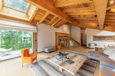 a living room with wooden ceilings and a large window at DIFY Chalet Contemporain - Les Praz de Chamonix in Chamonix-Mont-Blanc