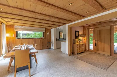 a dining room with a table and a kitchen at DIFY Chalet Contemporain - Les Praz de Chamonix in Chamonix-Mont-Blanc