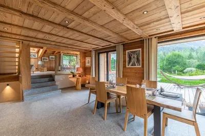 a dining room with a wooden table and chairs at DIFY Chalet Contemporain - Les Praz de Chamonix in Chamonix-Mont-Blanc