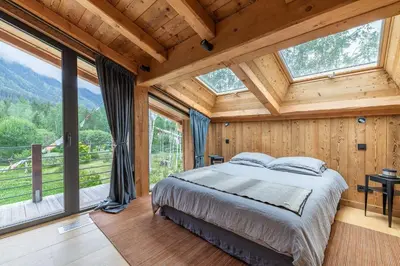 a bedroom with a bed in a room with windows at DIFY Chalet Contemporain - Les Praz de Chamonix in Chamonix-Mont-Blanc