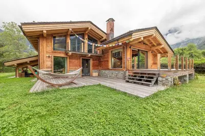 a log house with a hammock in front of it at DIFY Chalet Contemporain - Les Praz de Chamonix in Chamonix-Mont-Blanc