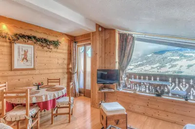 a dining room with a table and a large window at Appartement Megève - Welkeys in Megève