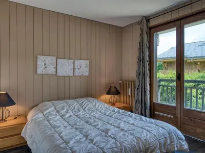 a bedroom with a bed and a large window at Appart 3 pièces proche télécabine - 5 pers - Wifi - Parking - FR-1-453-229 in Megève