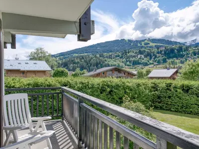 a white chair on a porch with a view of a mountain at Appart 3 pièces proche télécabine - 5 pers - Wifi - Parking - FR-1-453-229 in Megève