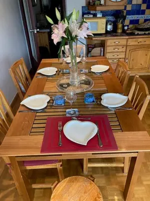 a wooden table with plates and a vase of flowers at ALPINSTAR in Chamonix-Mont-Blanc