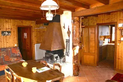 a living room with a table and a fireplace at Charmant appartement dans chalet in Les Carroz d'Araches