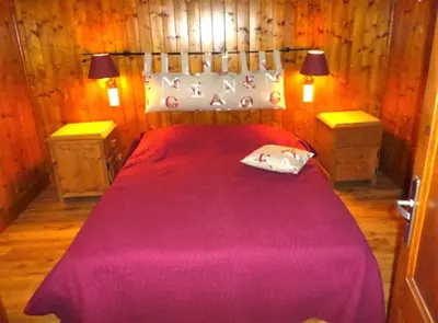 a bedroom with a large red bed with two night stands at Charmant appartement dans chalet in Les Carroz d'Araches