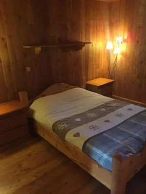 a bedroom with a bed in a wooden room at L'Atelier in Les Contamines-Montjoie