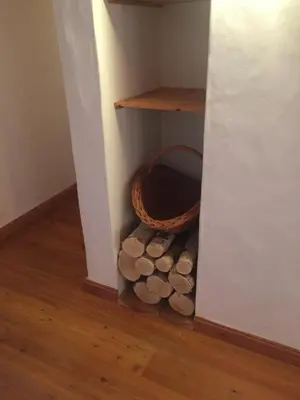 a corner of a room with a basket and logs at L'Atelier in Les Contamines-Montjoie