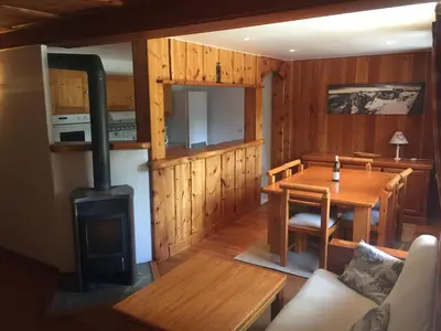 a living room with a wood stove and a table at L'Atelier in Les Contamines-Montjoie