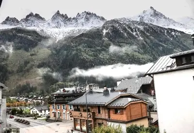 a town with mountains in the background with houses and buildings at Résidence Mummery Chamonix in Chamonix-Mont-Blanc