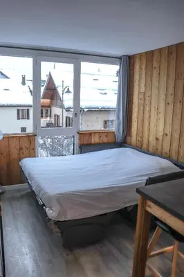 a large bed in a room with a large window at Résidence Mummery Chamonix in Chamonix-Mont-Blanc