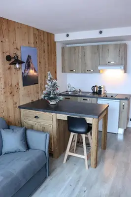 a kitchen with a table and a couch in a room at Résidence Mummery Chamonix in Chamonix-Mont-Blanc