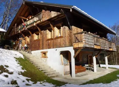 a large wooden house with stairs in the snow at Appartement Chalet Nerboux in Morillon