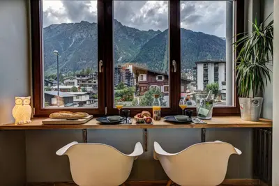 two white chairs sitting at a table in front of a window at Chamonix City Center Luxury Studio Apartment in Chamonix-Mont-Blanc