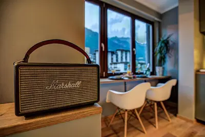 a briefcase sitting on top of a counter with white chairs at Chamonix City Center Luxury Studio Apartment in Chamonix-Mont-Blanc