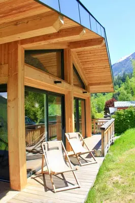 a group of chairs on a wooden deck at Modern Chalet With Garden Chamonix in Chamonix-Mont-Blanc