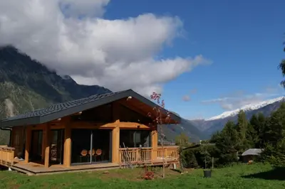 a log cabin with mountains in the background at Modern Chalet With Garden Chamonix in Chamonix-Mont-Blanc
