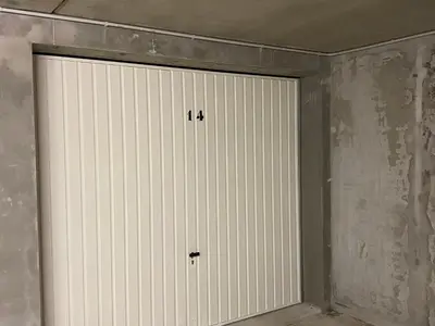 a cat sitting on top of a white garage door at Duplex 4 pièces pour 8 personnes au pied des pistes à Morillon - FR-1-815-76 in Morillon