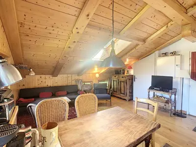 a living room with a couch and a table at Appartement cosy avec mezzanine, au pied des pistes à Combloux, parking inclus - FR-1-560-25 in Combloux