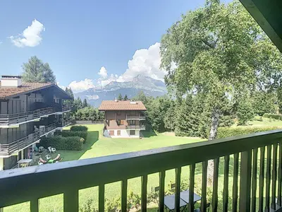 a balcony with a view of a house and a yard at Appartement cosy avec mezzanine, au pied des pistes à Combloux, parking inclus - FR-1-560-25 in Combloux
