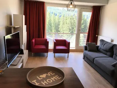 a living room with a couch and chairs and a large window at Residence Cassiopee - maeva Home in Flaine