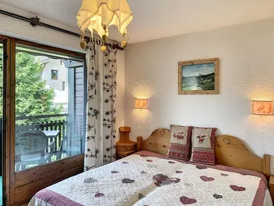 a bedroom with a bed and a balcony with a view at Charmant 2 pièces au centre de Combloux avec balcon - FR-1-560-2 in Combloux
