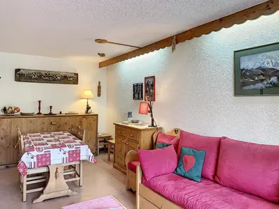 a living room with a pink couch and a table at Charmant 2 pièces au centre de Combloux avec balcon - FR-1-560-2 in Combloux