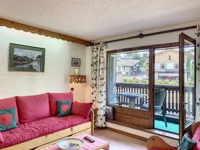 a living room with a red couch and a balcony at Charmant 2 pièces au centre de Combloux avec balcon - FR-1-560-2 in Combloux